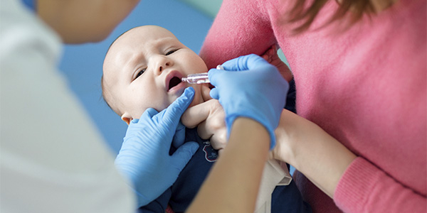 bebê tomando uma dose da vacina do Rotavírus